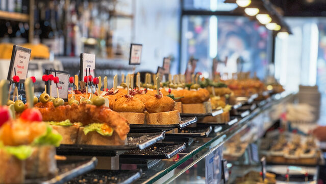 Variety of Spanish tapas served on plates in local bar in Barcelona