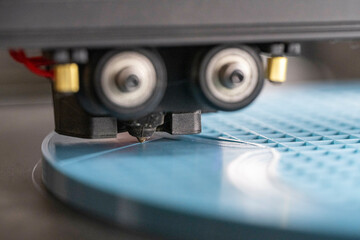 Close-up of a 3D printer nozzle working on light blue plastic material. Nijmegen, Netherlands