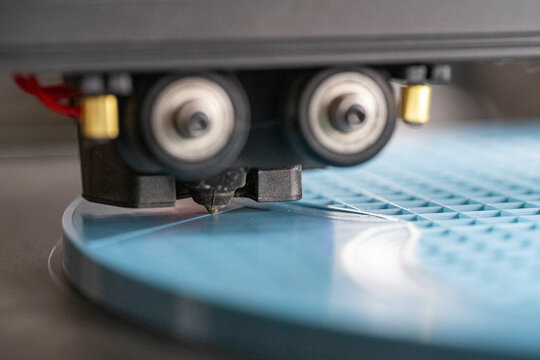 Close-up of a 3D printer nozzle working on light blue plastic material. Nijmegen, Netherlands