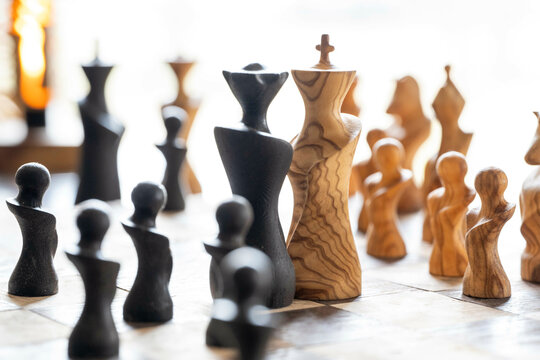 Artistic chess pieces on a board under bright natural lighting. Nijmegen, Netherlands