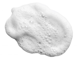 A white, frothy substance with bubbles, resembling soap foam, showcasing its airy texture and smooth surface.
