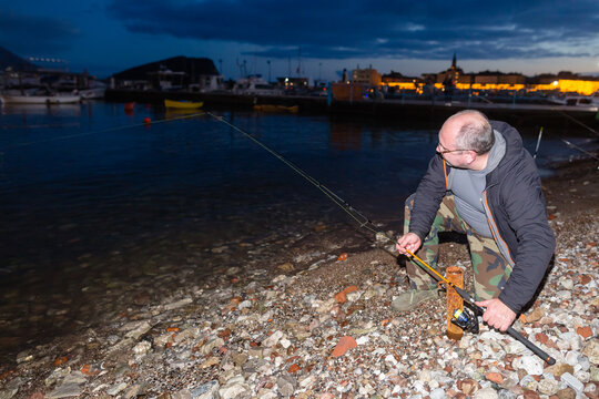 Fisher set up his telescopic fishing pole on the shore