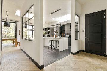 A sleek and contemporary kitchen featuring a minimalist aesthetic with dark cabinetry, light countertops, and an open layout that enhances space and functionality.