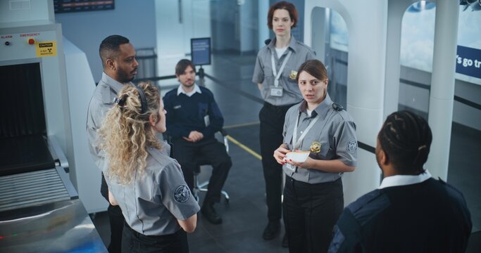 Airport Staff Briefing: Female Security Officer Providing Instruction, Holding Boarding Pass, Explaining Procedures and Specific Details to Team of Workers. Transportation Security Administration. - Powered by Adobe