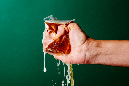 man crushes a plastic cup with beer in his hand