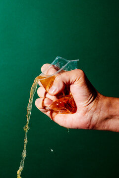 squeezes a plastic cup with beer