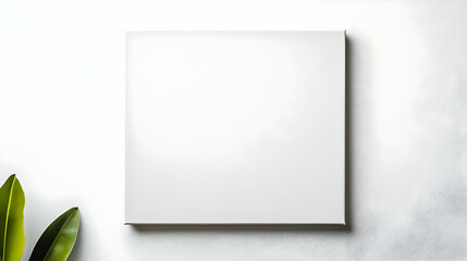 Blank White Square Canvas Mockup With Green Leaf Against Soft Background for Art and Design Display