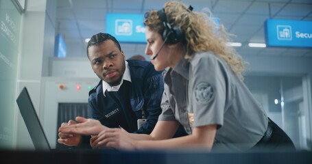Airport Security Checkpoint: Female Security Officer Wearing Headset Uses Laptop, Talks to African...