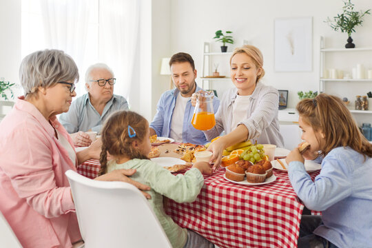 Happy big family people common meal three generation gathering, grown up adult children, senior grandparents, kids at home holiday together, homemade food, talking, laughing, enjoying leisure time 