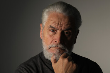 Portrait of bearded senior man on grey background