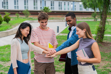 Enthusiastic young students celebrating teamwork and friendship with a group high five in a joyful outdoor setting filled with academic energy and youthful spirit among peers