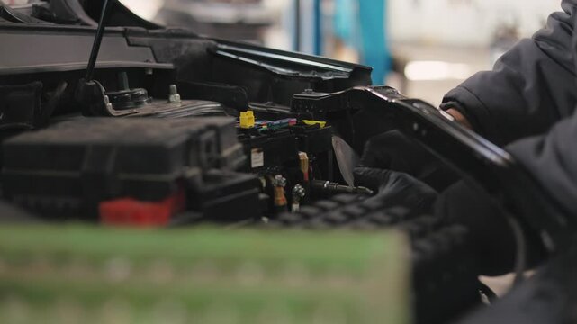 
Automotive electrician - automobile service diagnostics, checking electro fuse relay in car, small business.Car engine repair electrician, open hood.