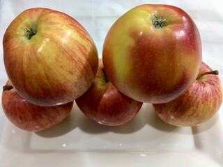 Juicy, shiny red apples on a white background.