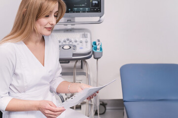 Female professional doctor resding ultrasound examination results reading medical records, case history, examination report thinking about diagnosis at workplace in office communicating 