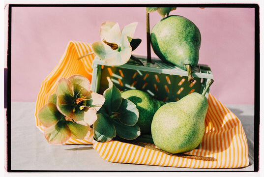 Fresh green pears arranged with flowers on a vibrant background