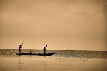 Silhouettes at Dawn: Traditional Fishing on Calm Waters