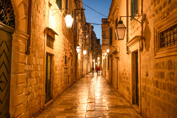 Obraz premium a narrow stone street in the old town of Dubrovnik, illuminated by lanterns at night
