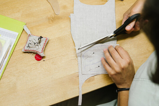 A woman cuts out a mold.