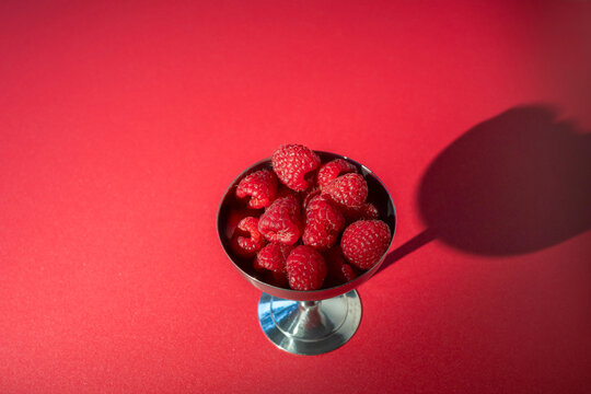 Fresh Raspberries in a Metal Cup on Red Background