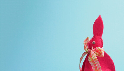 Pink Easter bunny on a blue paper background with space for your Easter greetings