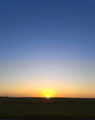 Obraz premium Sunset over a field in the evening. Beautiful landscape with sunset.