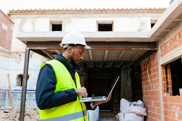 Construction manager using laptop during building renovation