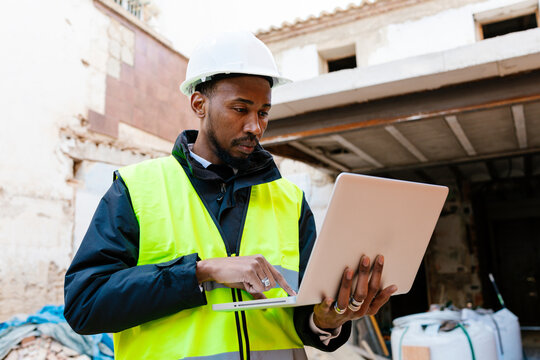 Construction manager using laptop during building inspection
