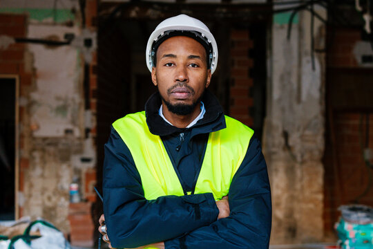 A construction worker poses with his arms crossed.