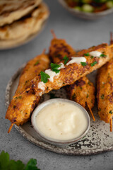 Chicken Kofta Kebab on wooden skewers with pita, garlic sauce Toum, parsley, lemon, cucumber and tomato. Shish kafta tavuk. Traditional Middle East food. Lebanese, Turkish cuisine. Food photography.