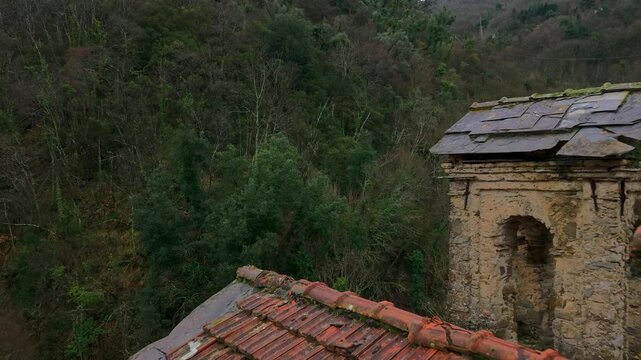 Abandoned church, Santa Maria di Lago Pigo, Nostra Signora di Nogareto or Madonna dell&rsquo;Assunta, details of bell tower and roof. Aerial drone backward rooftop