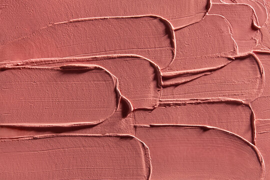Abstract texture of soft peach toned lipstick layered in strokes
