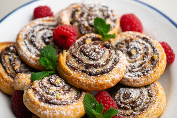 Delicious puff pastry rolls filled with cocoa cream and pistachios.
