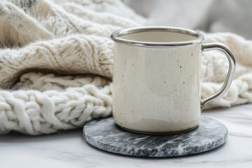 Cozy winter mug on marble. Warm knitted blanket in background