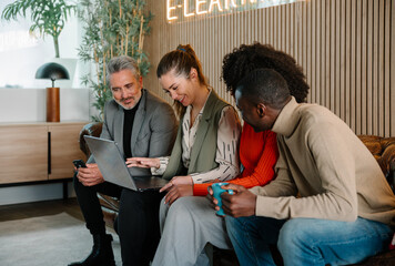 Collaborative business meeting with diverse team using a laptop
