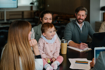 Baby at workplace: a joyful moment in a casual meeting setting