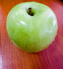 Single green apple on a wooden surface