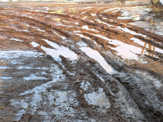 winter driveway with snow, puddles, and mud