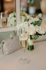 Champagne glasses, bridal bouquet on table, wedding details