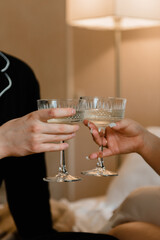 Glasses of champagne in the hands of the bride and groom, close-up