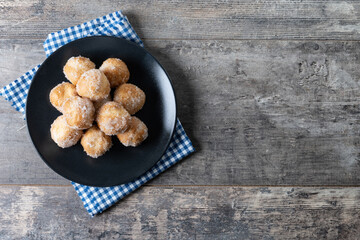 Traditional Carnival fritters or buñuelos de viento on wooden table. Top view. Copy space