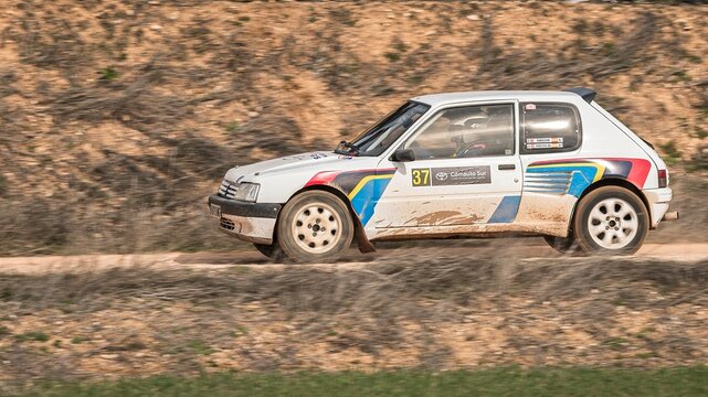 Madrid, Spain; 02-15-2025: A Peugeot 205 GTI roars in the rally, sliding along the dirt track at full speed. A perfect capture of motorsport intensity