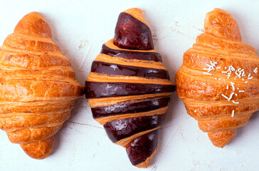 Three croissants with different fillings on a white background. Assortment of puff pastry. Top view