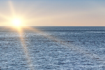Beautiful sunrise on the ocean. Rays of sun over the sea. Dawn sky over the sea.