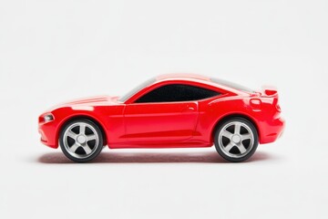 Obraz premium A small red toy car sits in a bright white studio