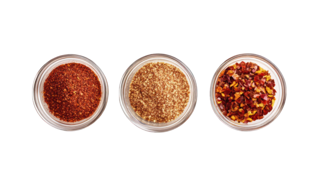 Crushed red cayenne pepper, dried chili flakes, and ground paprika, top view --ar 16:9