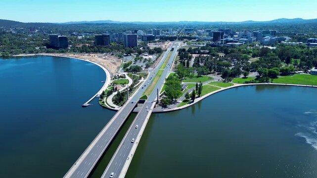 Drone aerial landscape of car vehicles traffic driving across bridge overpass road highway over Lake Burley Griffin Molonglo river in Canberra city capital ACT Australia travel transport urban tourism