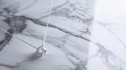 Minimalist modern necklace with a single diamond pendant, draped over a smooth marble surface for a luxury aesthetic.