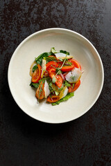 A fresh and vibrant vegetable salad, elegantly plated in a restaurant-style presentation.