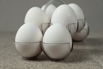Fresh raw chicken eggs in egg stand close-up.