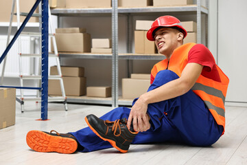 Accident at work. Injured man on floor in warehouse